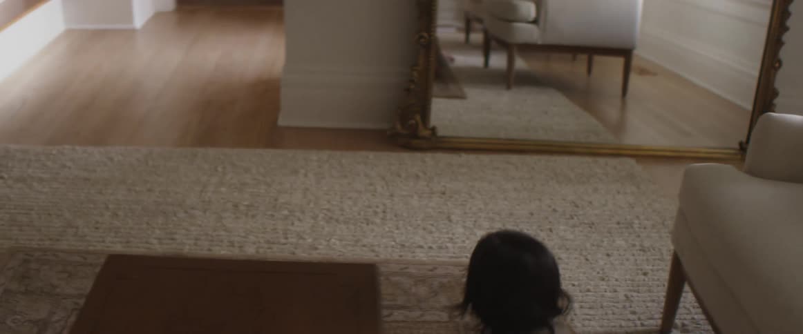 A father crawls on the ground with his child while  playing