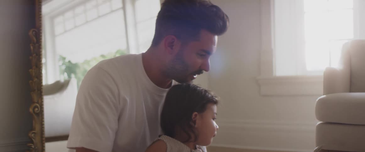 Father reading to his child on the floor of the living room