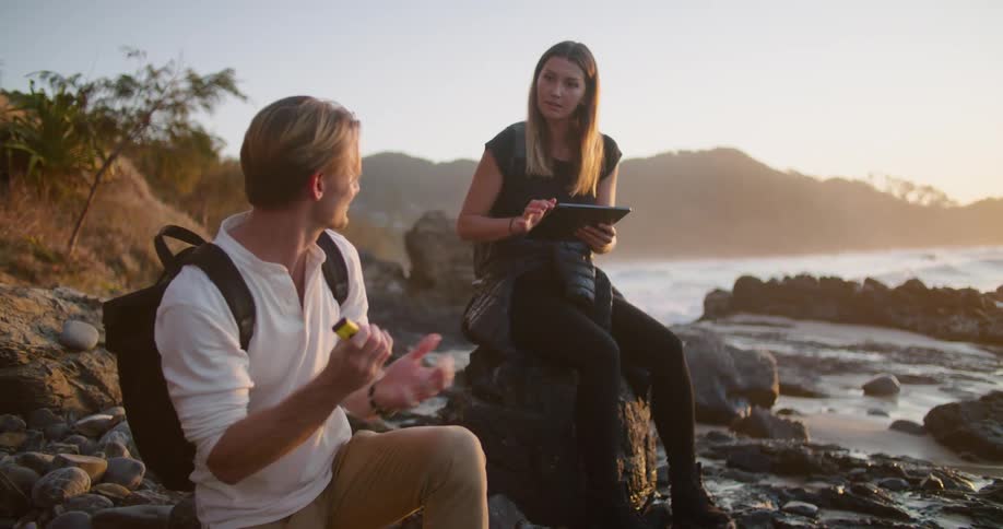 Two people sitting at the coast talking