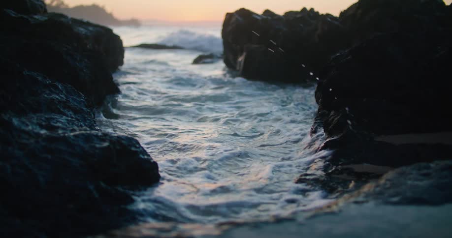 A close up of water getting into a small hole on a beach