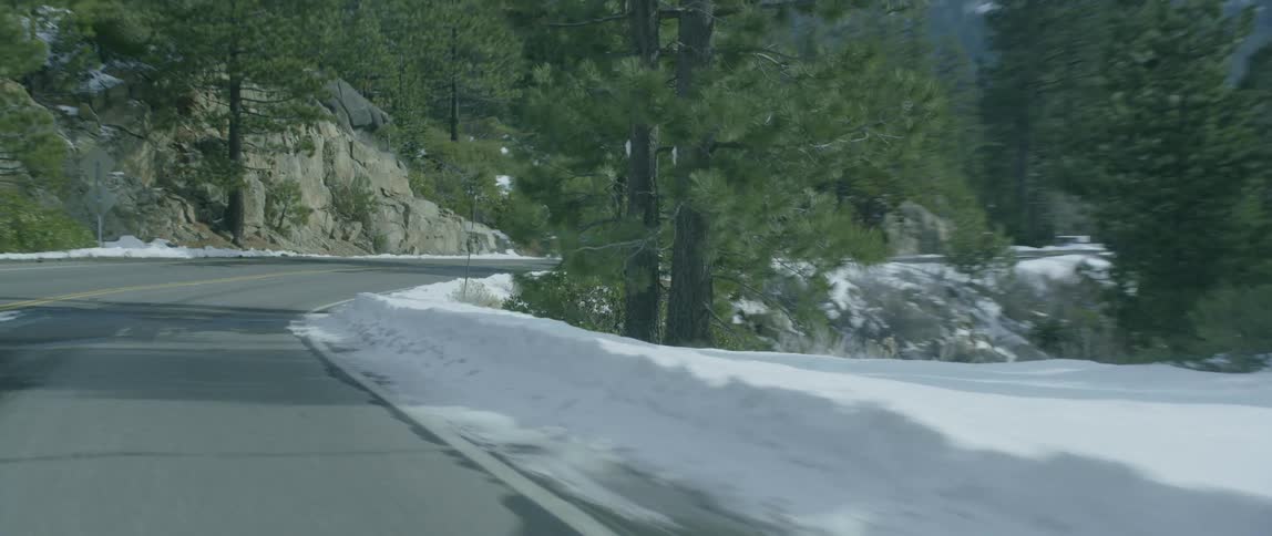 A  sports car drives in snowy mountains
