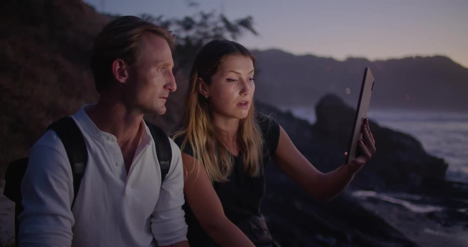 Two people talking to a tablet