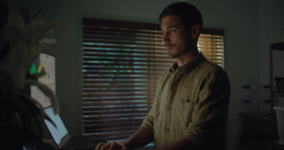 A man types on his computer while working from a home office