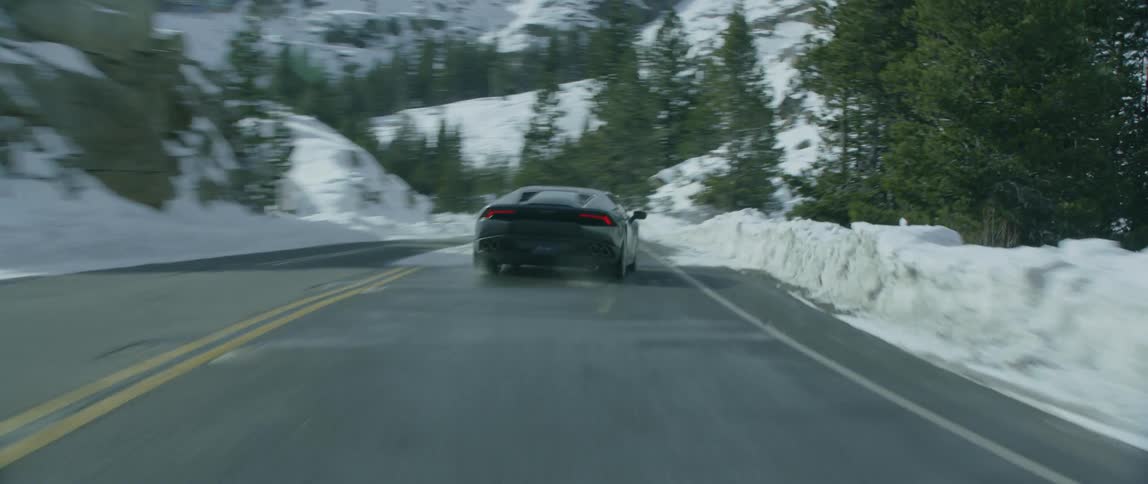 Sports car pulling out onto a winding road on a winter day
