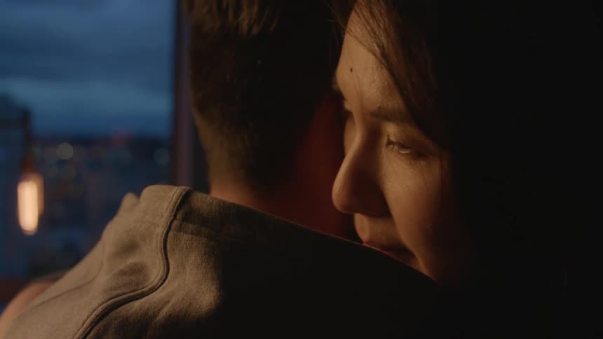 A couple hug by the window