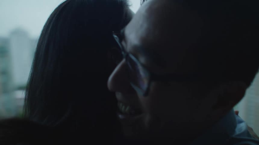 Two people hug by the window