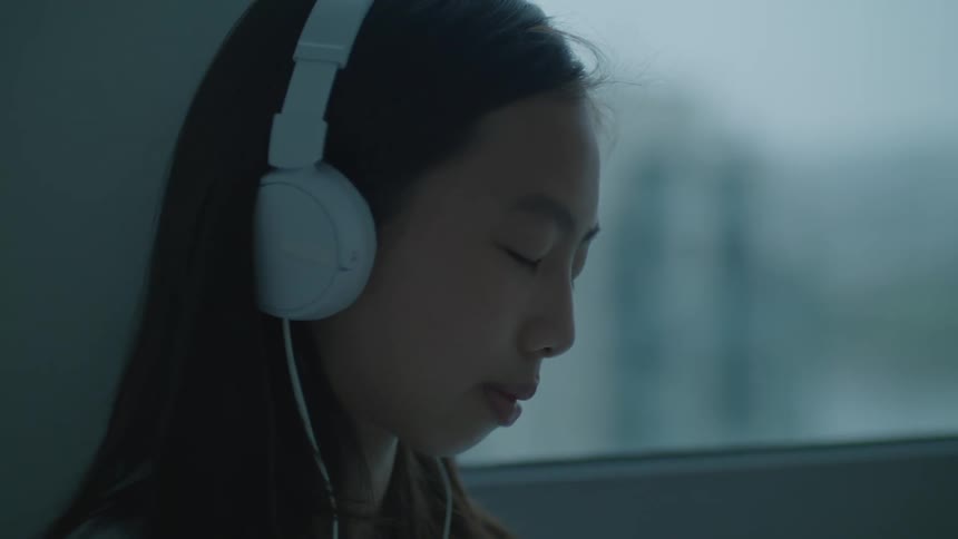A woman nodding away with headphones on