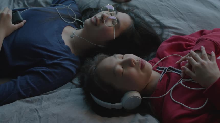 Two girls rest in bed together
