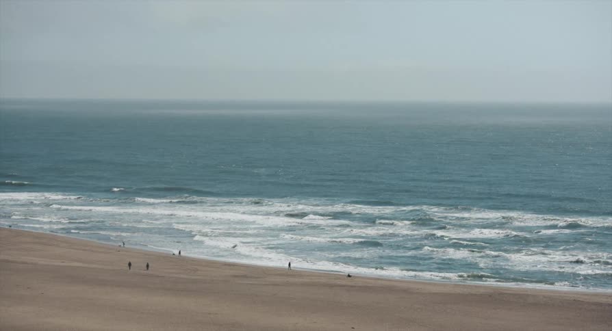 People are walking around the beach in the distance