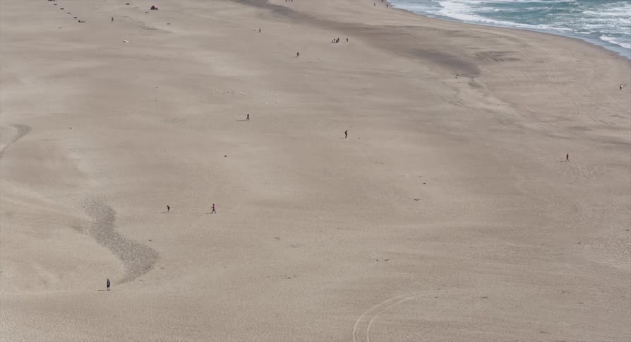 Waves roll ashore a sandy beach