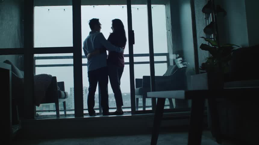 Couple hug each other on the apartment balcony