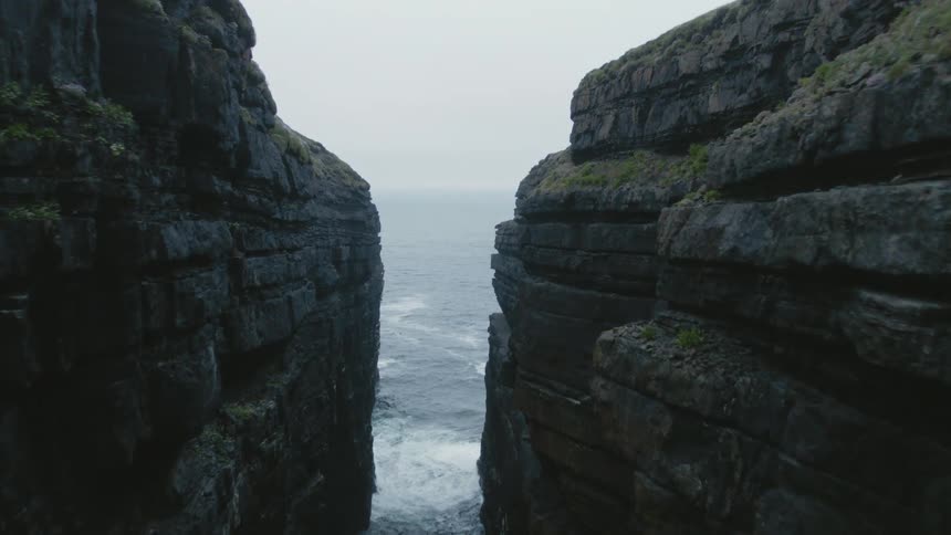 The ocean flows between two cliffs