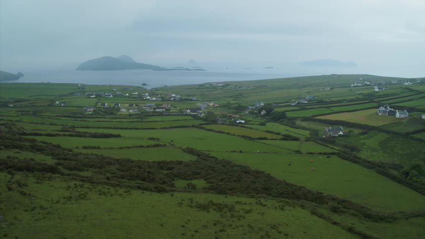 Coastal farming village with rolling hills and green fields