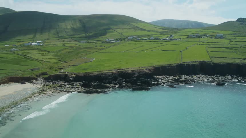 An ocean lagoon sits near farmland and a rural village