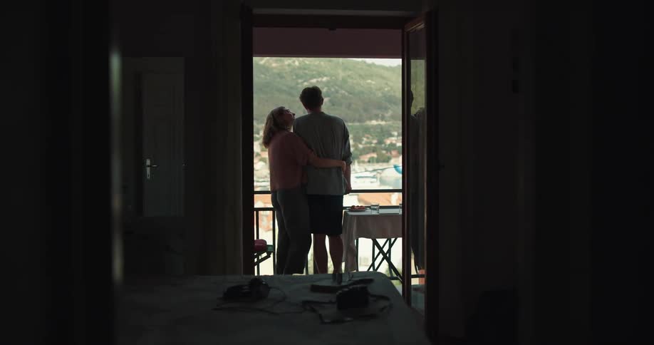 Two people standing and looking out into a city