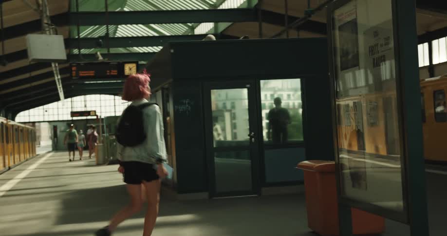 Woman with hot pink dyed hair changes trains at train station
