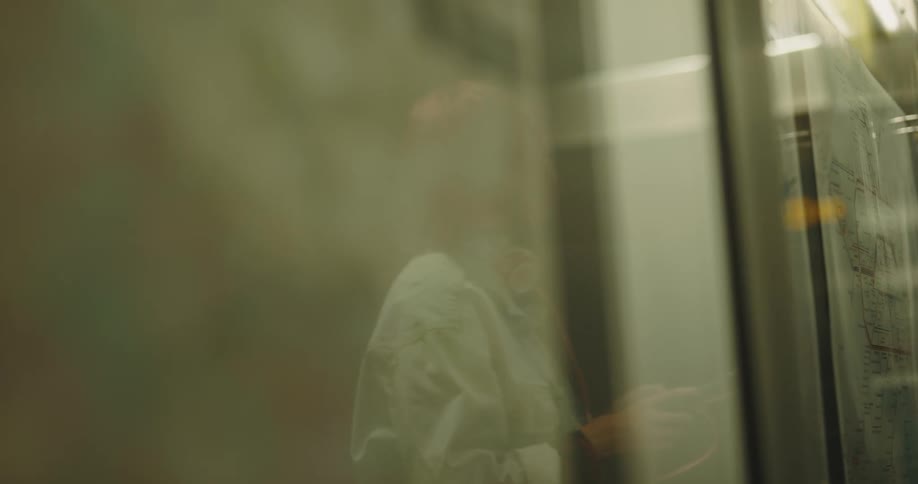 A woman examines a subway map while using her smartphone