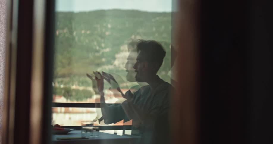 A reflection of a man talking to another person