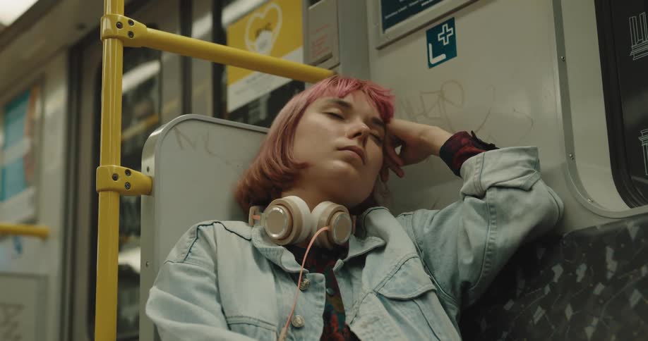 A young woman is falling asleep while riding the subway