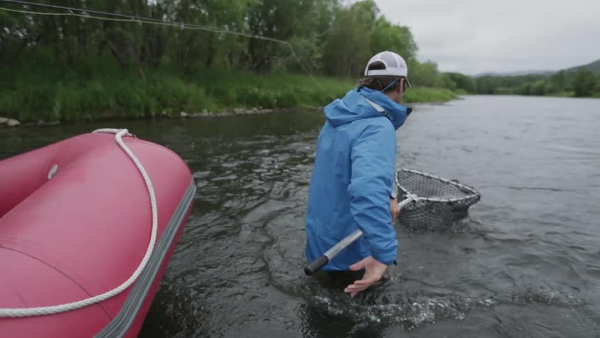 A man lifts a fish up in a net
