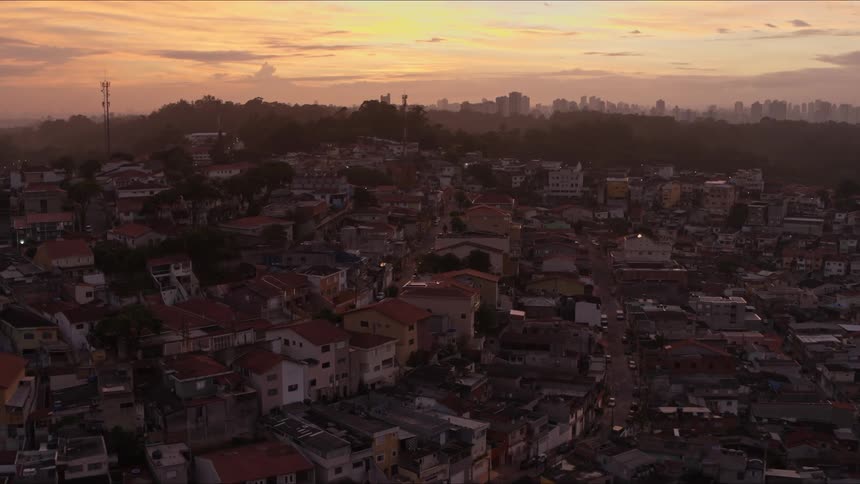Aerial view of suburban neighborhood in golden hour with city skyline in the background