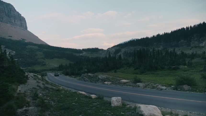 Car driving down curvy mountain road