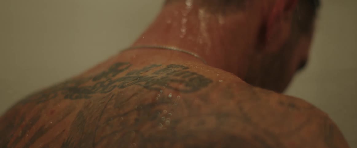A man shakes his head back and forth during a shower