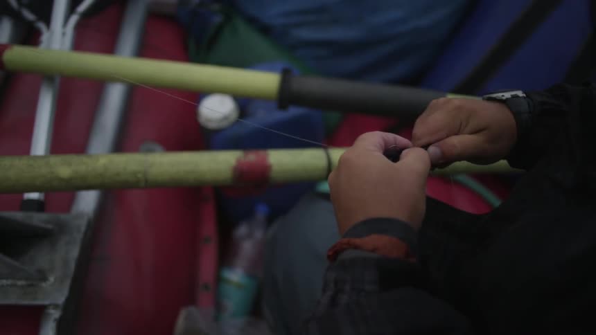 A man cuts the line of his fishing pole
