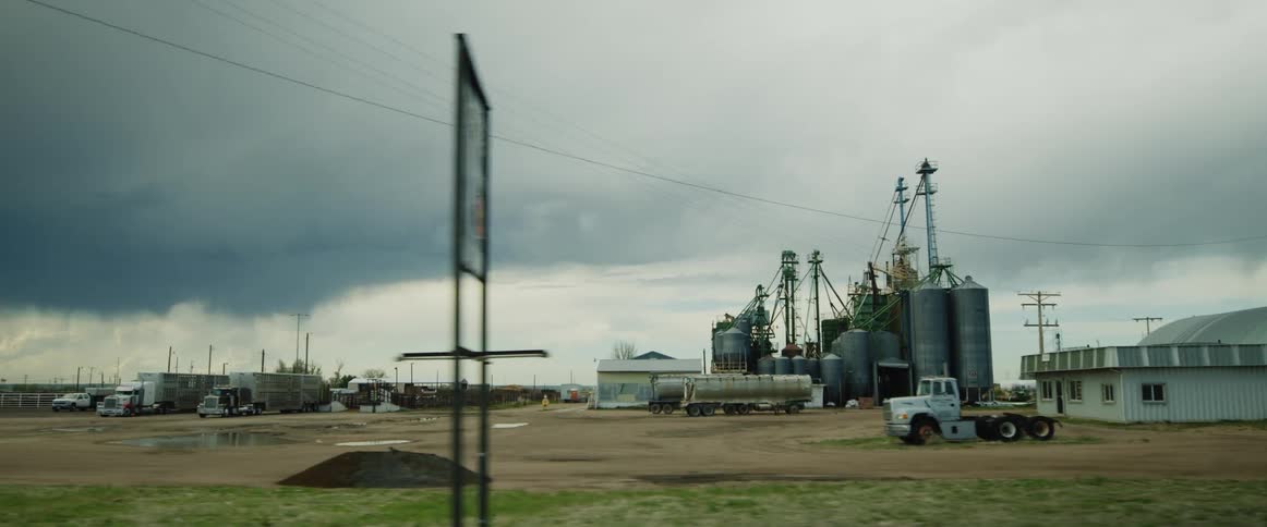 A refinery in a field on a cloudy day