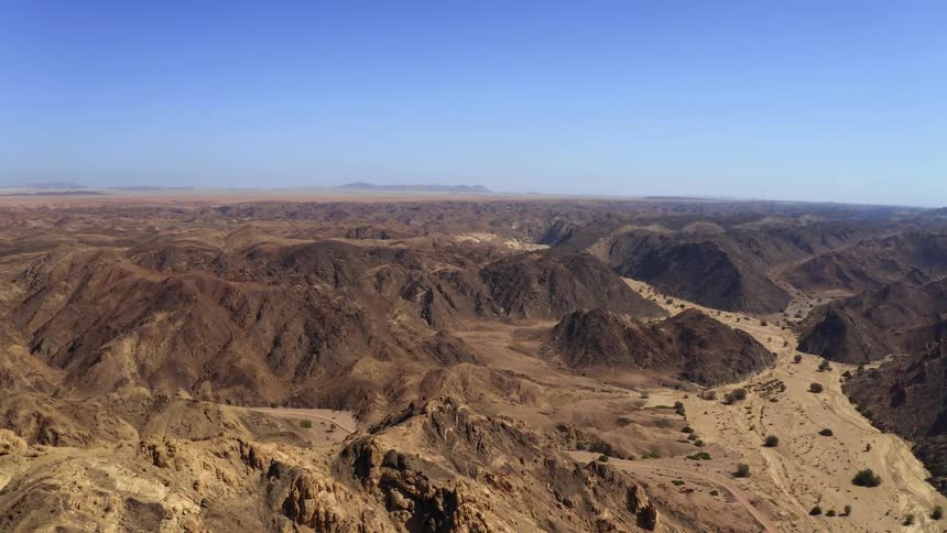 An aerial view of a valley and mountains in the desert