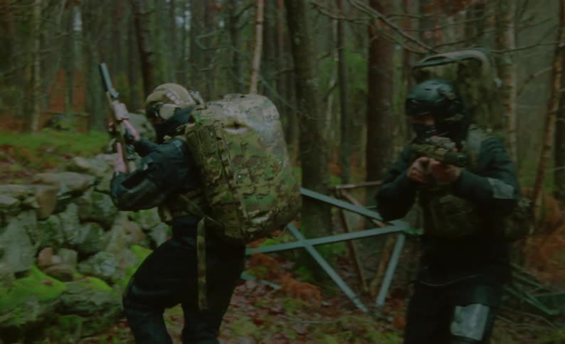 Two soldiers walking around in a forest