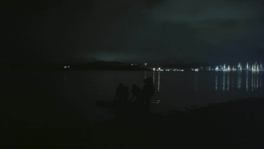 A group of people walking next to a lake