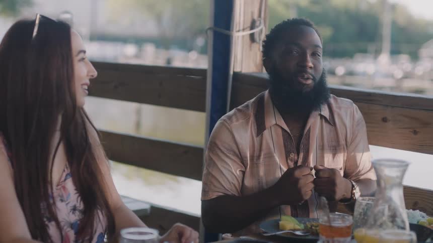 A man and a woman are sitting down in a restaurant talking