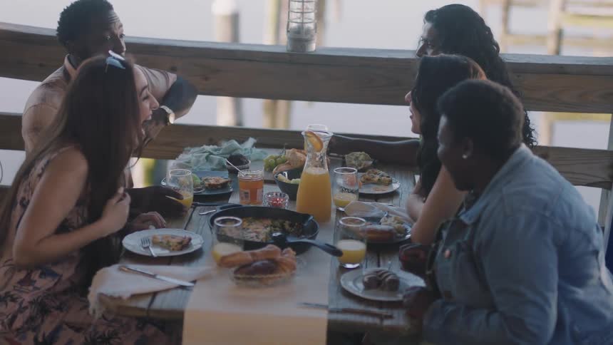 Friends are having conversation while having breakfast at a restaurant during the day