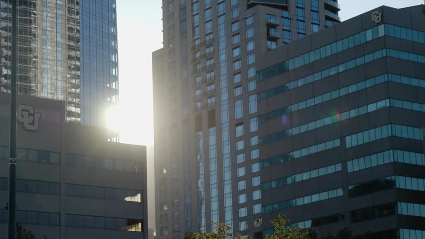 Sun shines past skyscrapers through gap between two buildings
