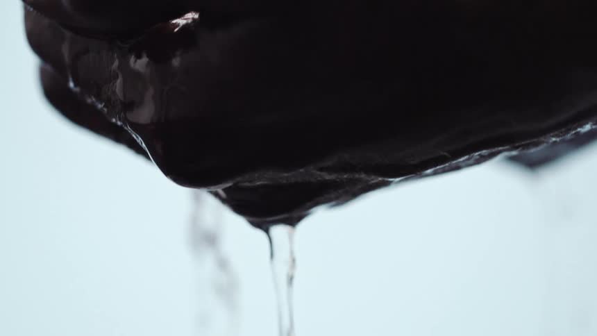 A man scoops water with his cupped hands and lets it drip through his fingers