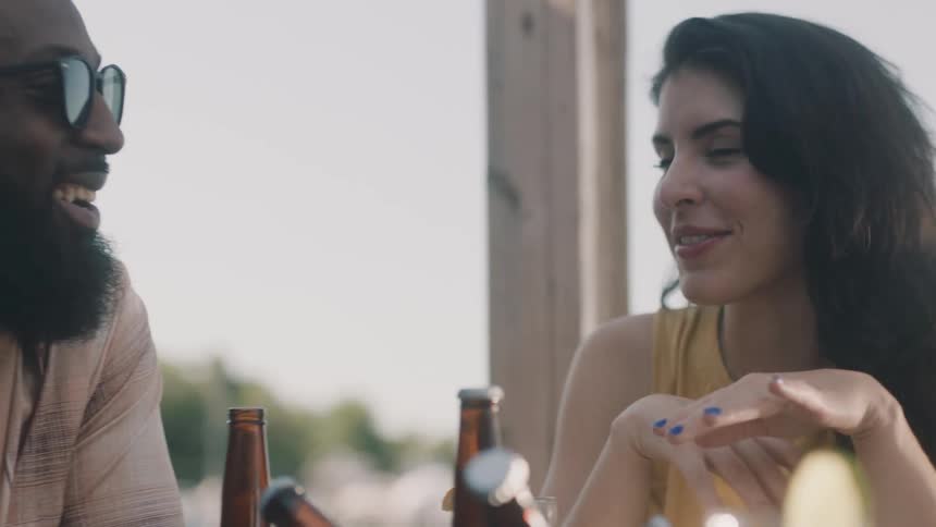 A couple have drinks by the water