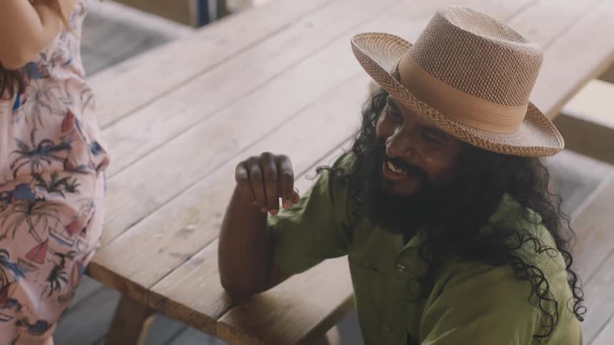 A man is sitting at a table talking to friends