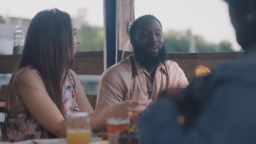 Friends talk at a table with drinks
