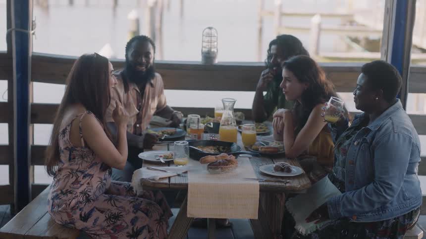 Friends are enjoying themselves having breakfast together in a restaurant during the day