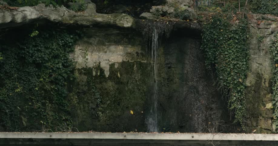 Small waterfall drops from low point in park