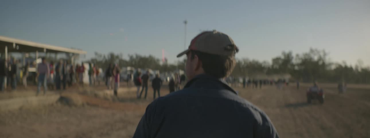 A man walks past a crowd on the sidelines
