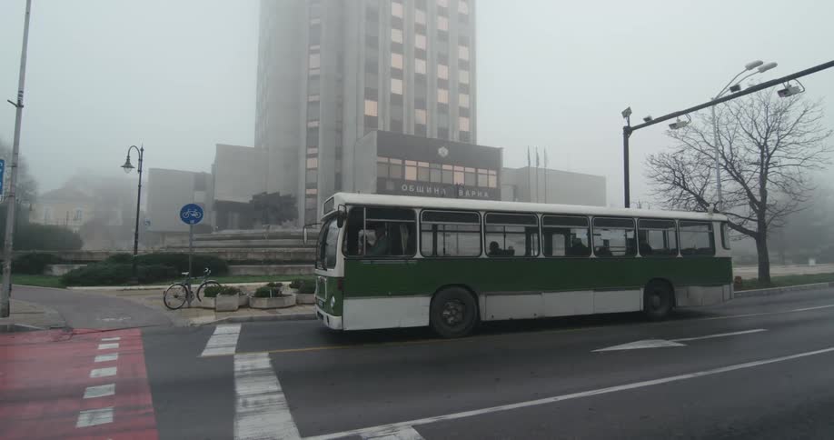 A bus is stopped at the corner in the city