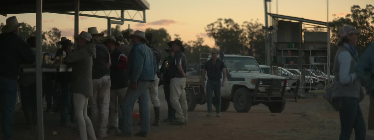 Man pulls up in truck and joins others at bar under red sky