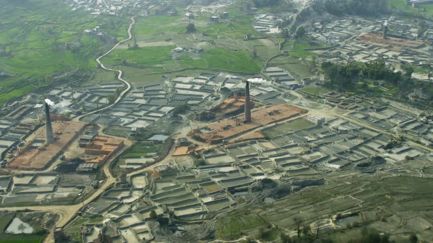 A plant with smoke stacks is flown over