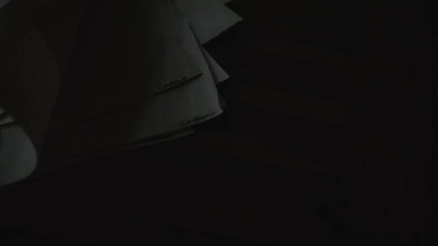Papers sitting on a surface are blown by a breeze
