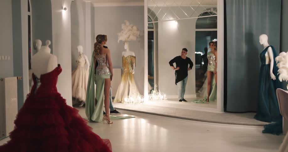 A woman trying on a dress in a studio