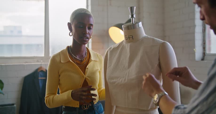 Man and woman discuss tailoring of top on dressmakers dummy