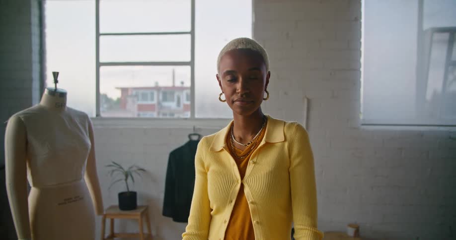 A woman in a room with a mannequin with a wall and window in the background
