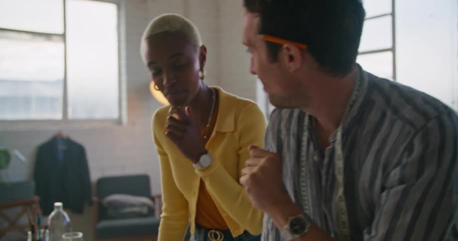 A man and a woman in a room with a mannequin with a wall and window in the background